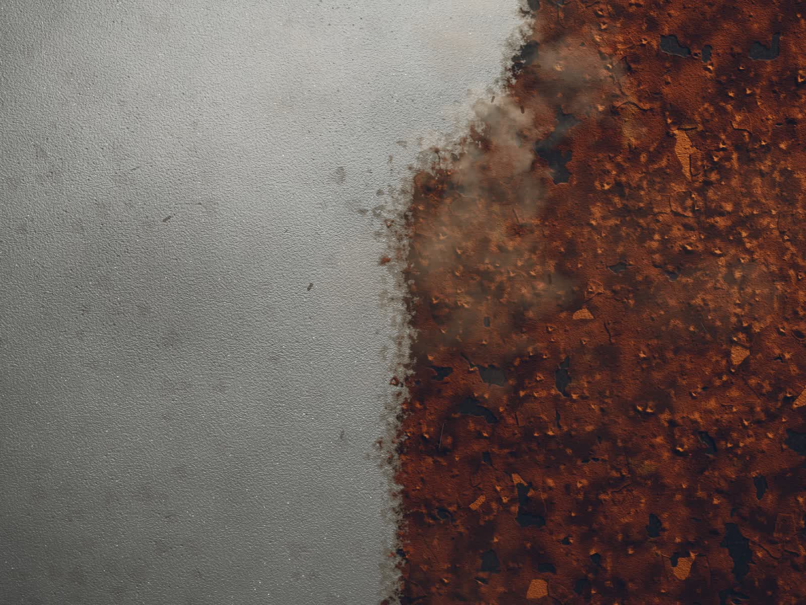 Stahlplatte von oben im Streiflicht: links blank gestrahlt, rechts noch verrostet, an der Grenze arbeitet der Strahl mit Staubwolke